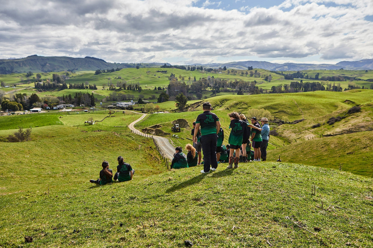 School kids visiting farm overlooking view in New Zealand